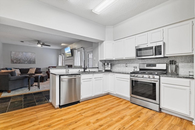 736 Fawn Valley Dr, Allen, TX 75002 - kitchen featuring appliances with stainless steel finishes, a sink, white cabinets, and a textured ceiling