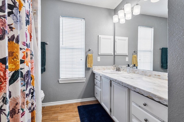 736 Fawn Valley Dr, Allen, TX 75002 - bathroom with wood finished floors, vanity, toilet, a textured wall, and baseboards