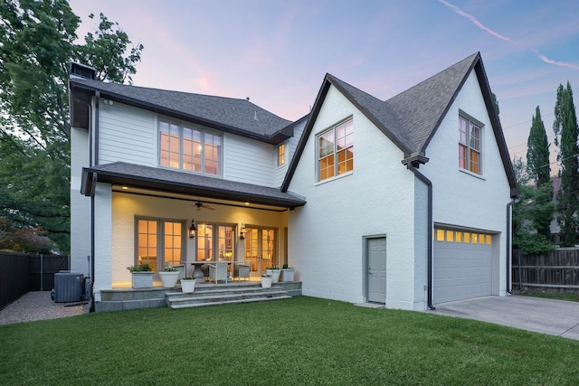 2905 Amherst Ave, University Park, TX 75225 - back of property at dusk with a garage, driveway, ceiling fan, central air condition unit, and a shingled roof