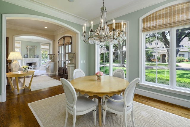 2905 Amherst Ave, University Park, TX 75225 - dining area featuring healthy amount of natural light, wood finished floors, arched walkways, crown molding, and a fireplace