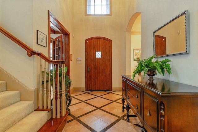 1420 Kensington Ct, Southlake, TX 76092 - foyer entrance with arched walkways, stairs, inlaid floor details, a high ceiling, and baseboards