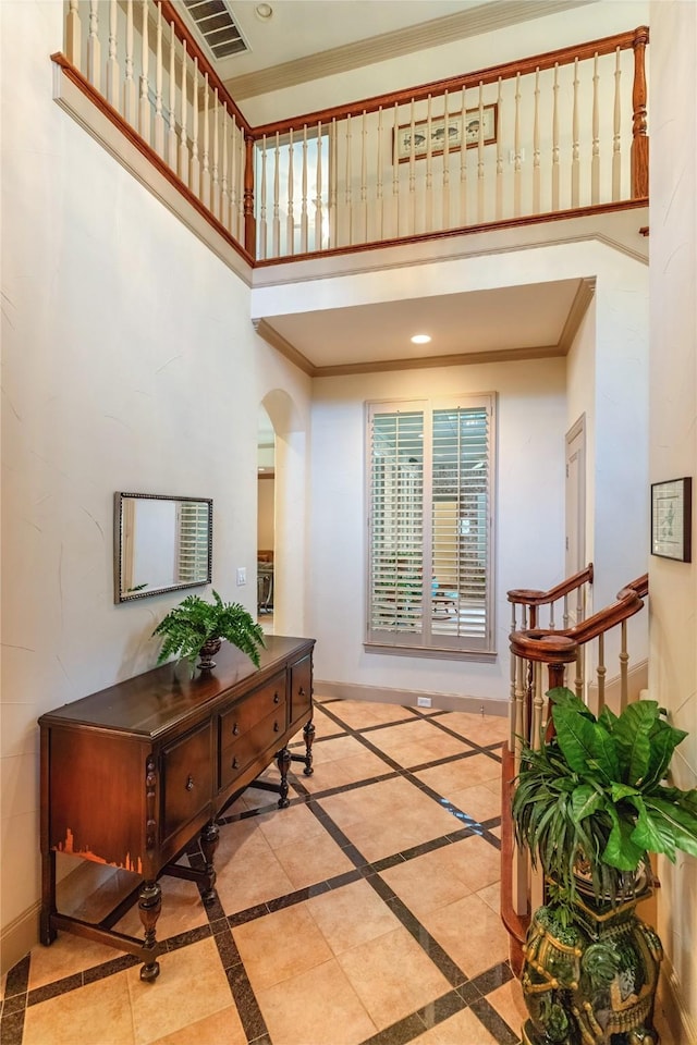 1420 Kensington Ct, Southlake, TX 76092 - entryway featuring a towering ceiling, crown molding, arched walkways, inlaid floor details, and baseboards