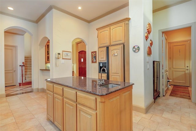 1420 Kensington Ct, Southlake, TX 76092 - kitchen featuring a sink, a kitchen island with sink, dark stone countertops, arched walkways, and baseboards