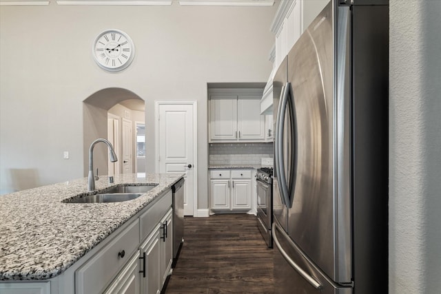 1108 Summer Ln, Mckinney, TX 75071 - kitchen with a sink, appliances with stainless steel finishes, arched walkways, white cabinetry, and a center island with sink