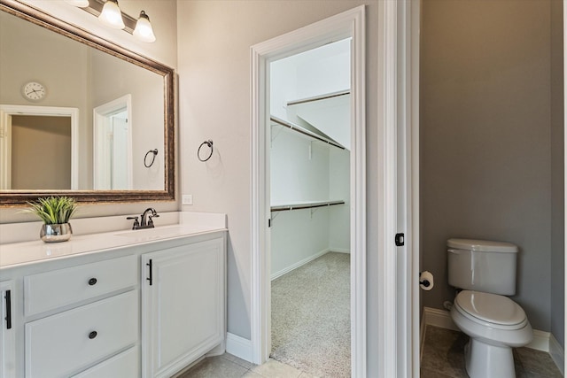 1108 Summer Ln, Mckinney, TX 75071 - bathroom featuring vanity, toilet, a spacious closet, baseboards, and tile patterned floors