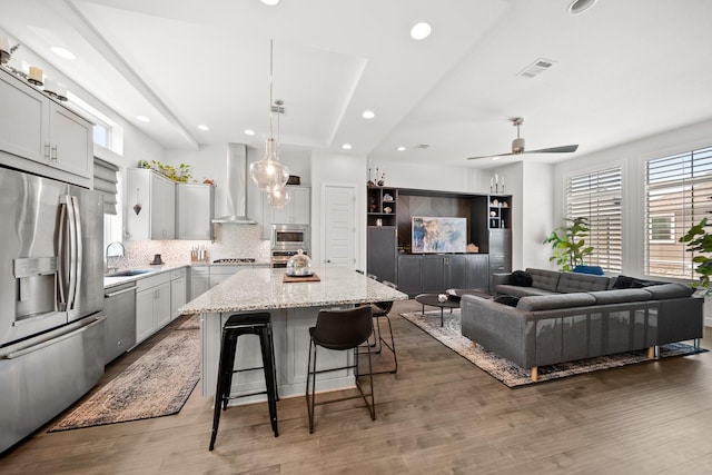 1844 Stevens Bluff Ln, Dallas, TX 75208 - kitchen with appliances with stainless steel finishes, wall chimney exhaust hood, a center island, tasteful backsplash, and a kitchen breakfast bar
