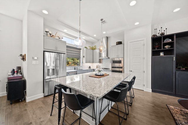 1844 Stevens Bluff Ln, Dallas, TX 75208 - kitchen featuring stainless steel appliances, wall chimney range hood, a center island, recessed lighting, and light stone counters