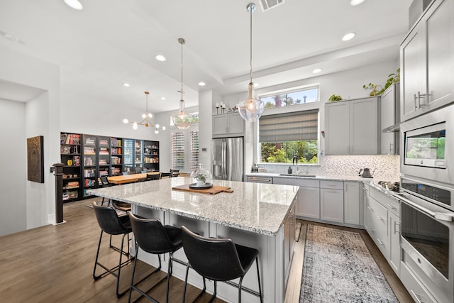 1844 Stevens Bluff Ln, Dallas, TX 75208 - kitchen with appliances with stainless steel finishes, gray cabinetry, a center island, recessed lighting, and tasteful backsplash