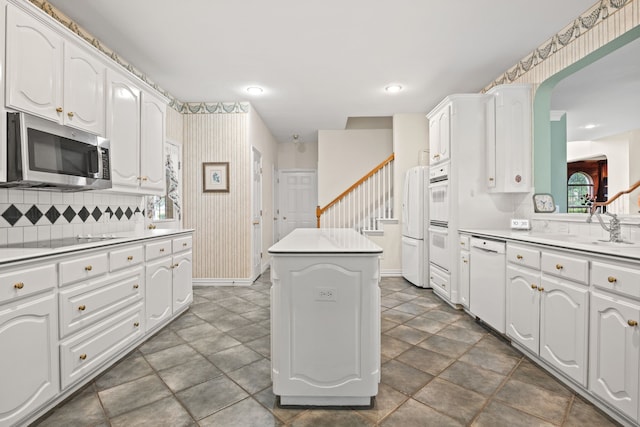 205 Lovegrass Ln, Southlake, TX 76092 - kitchen featuring white appliances, a center island, wallpapered walls, white cabinets, and recessed lighting