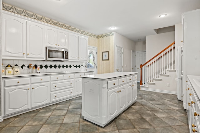 205 Lovegrass Ln, Southlake, TX 76092 - kitchen featuring stainless steel microwave, a center island, white cabinetry, light countertops, and electric cooktop