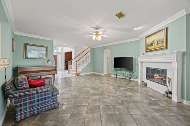 205 Lovegrass Ln, Southlake, TX 76092 - living room featuring stairs, crown molding, a tiled fireplace, ceiling fan, and arched walkways