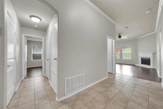 1209 Evers Dr, Mckinney, TX 75071 - hall with light tile patterned floors, crown molding, baseboards, and arched walkways