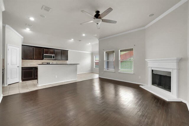 1209 Evers Dr, Mckinney, TX 75071 - unfurnished living room with crown molding, ceiling fan, a fireplace with raised hearth, recessed lighting, and light wood-type flooring