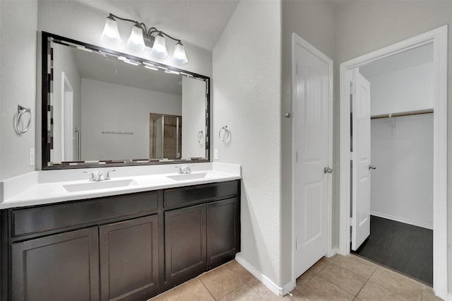 1209 Evers Dr, Mckinney, TX 75071 - bathroom with double vanity, tile patterned flooring, a walk in closet, and baseboards