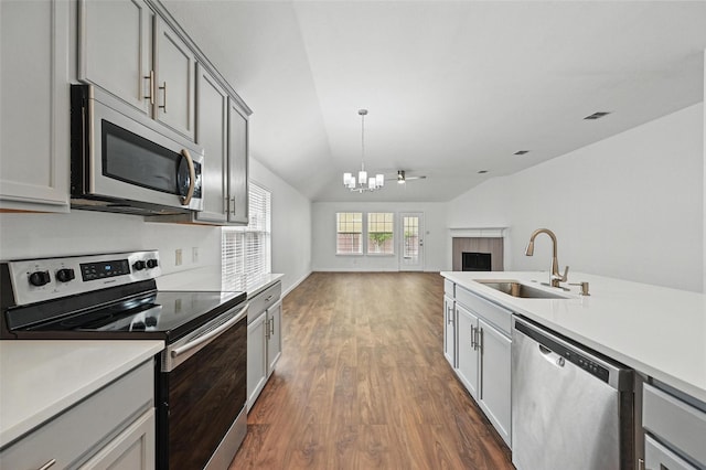 6609 Adobe Cir, The Colony, TX 75056 - kitchen with appliances with stainless steel finishes, a sink, gray cabinets, a chandelier, and dark wood finished floors