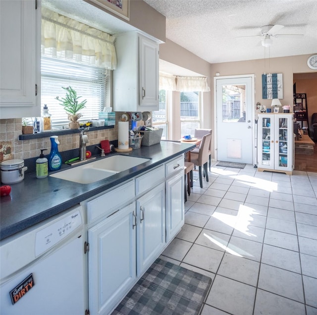 3506 Bryan St, Sachse, TX 75048 - kitchen with white dishwasher, a sink, backsplash, white cabinetry, and dark countertops