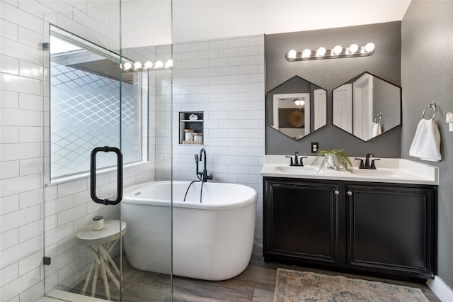 990 Lancashire Ln, Prosper, TX 75078 - full bath featuring double vanity, wood finished floors, a freestanding tub, a stall shower, and tile walls