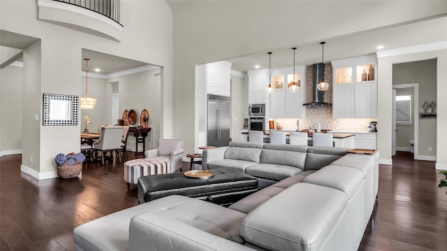 8162 Edgefield Ct, Frisco, TX 75035 - living room with a chandelier, dark wood-style floors, a high ceiling, recessed lighting, and crown molding