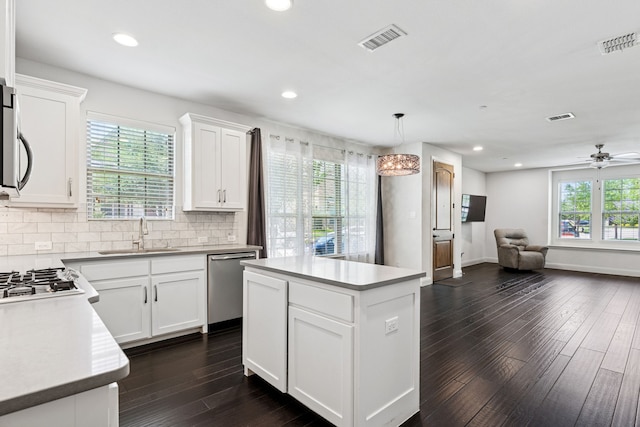 4682 Rhett Ln Unit A, Carrollton, TX 75010 - kitchen featuring stainless steel appliances, a sink, open floor plan, dark wood finished floors, and a center island