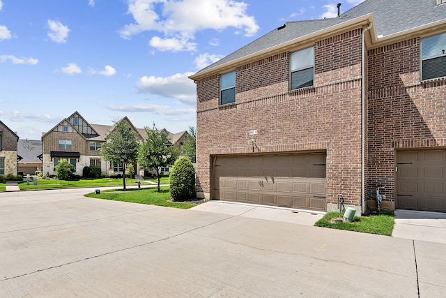 4682 Rhett Ln Unit A, Carrollton, TX 75010 - view of side of home with brick siding, a garage, driveway, and a residential view