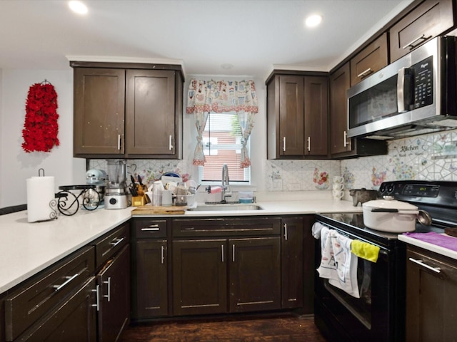 1926 E Overton Rd, Dallas, TX 75216 - kitchen with black electric range, stainless steel microwave, a sink, dark brown cabinetry, and light countertops