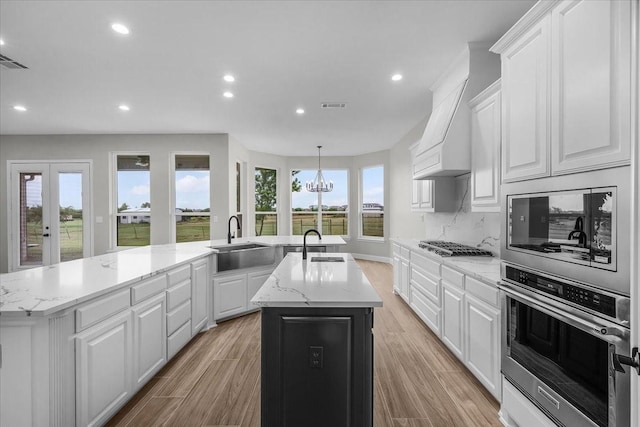 10817 Ridge Country Rd, Haslet, TX 76052 - kitchen with stainless steel oven, a sink, an island with sink, recessed lighting, and white cabinets