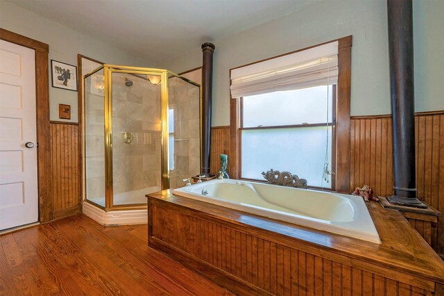 1909 Alston Ave, Fort Worth, TX 76110 - full bath with a wood stove, wainscoting, a stall shower, a bath, and wood finished floors