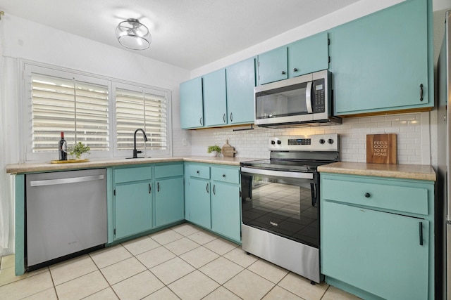 5044 Avery Ln, The Colony, TX 75056 - kitchen featuring appliances with stainless steel finishes, tasteful backsplash, light countertops, light tile patterned flooring, and a sink