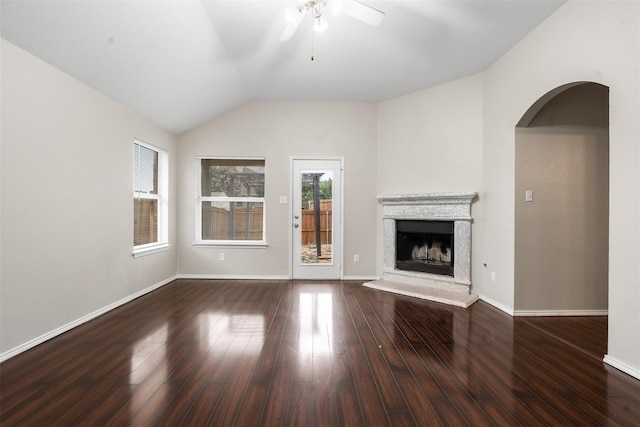 648 Tabasco Trl, Arlington, TX 76002 - unfurnished living room with a ceiling fan, a fireplace with raised hearth, wood finished floors, vaulted ceiling, and arched walkways