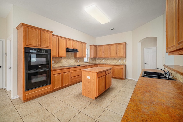 5516 La Bandera Trl, Benbrook, TX 76126 - kitchen with black appliances, a sink, backsplash, arched walkways, and a center island