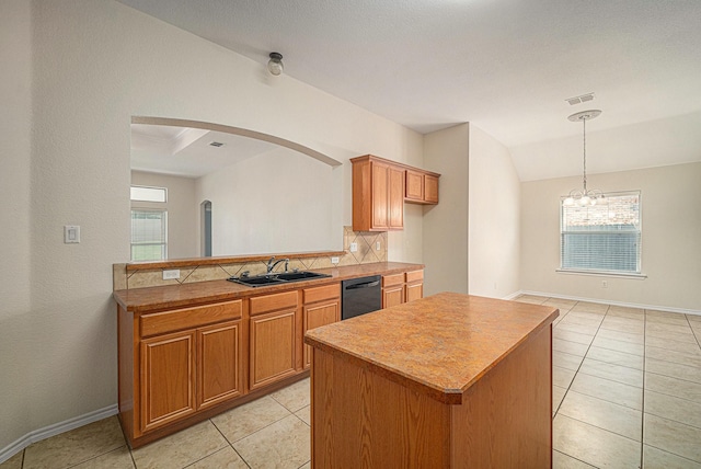 5516 La Bandera Trl, Benbrook, TX 76126 - kitchen featuring a sink, tasteful backsplash, black dishwasher, arched walkways, and brown cabinetry