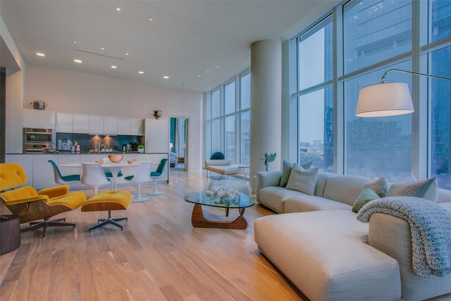 1918 N Olive St Unit 302, Dallas, TX 75201 - living area with a towering ceiling, plenty of natural light, expansive windows, recessed lighting, and light wood-style flooring
