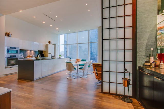 1918 N Olive St Unit 302, Dallas, TX 75201 - kitchen with modern cabinets, white cabinetry, double oven, recessed lighting, and expansive windows