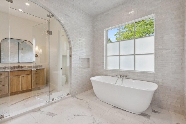 1801 Loving Ave, Dallas, TX 75214 - bathroom featuring vanity, marble tiled flooring, and a soaking tub
