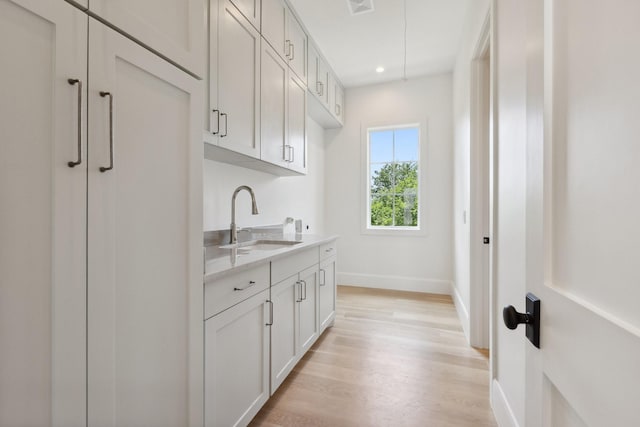 1801 Loving Ave, Dallas, TX 75214 - laundry area featuring a sink, light wood finished floors, baseboards, and recessed lighting