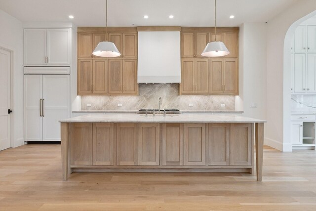 1801 Loving Ave, Dallas, TX 75214 - kitchen with paneled fridge, premium range hood, backsplash, arched walkways, and recessed lighting