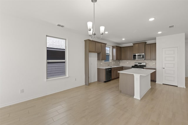3121 Dixondale Dr, Fort Worth, TX 76108 - kitchen with appliances with stainless steel finishes, a sink, tasteful backsplash, light wood-style floors, and light countertops