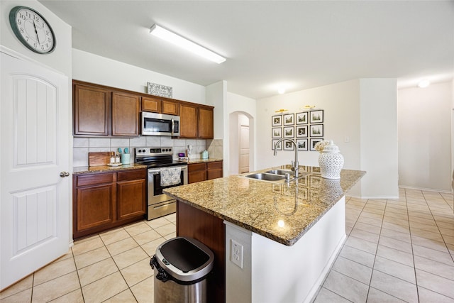 806 Opal Path, Princeton, TX 75407 - kitchen featuring appliances with stainless steel finishes, a sink, arched walkways, and light tile patterned floors