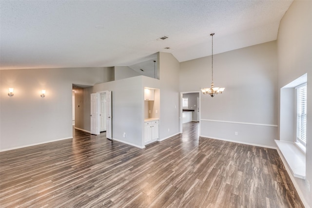 6704 Wesson Dr, Plano, TX 75023 - unfurnished living room with high vaulted ceiling, a chandelier, wood finished floors, and baseboards
