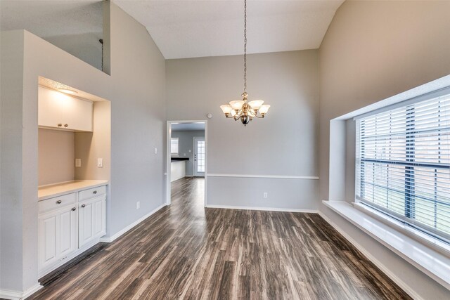 6704 Wesson Dr, Plano, TX 75023 - unfurnished dining area featuring high vaulted ceiling, dark wood-style flooring, a chandelier, and baseboards