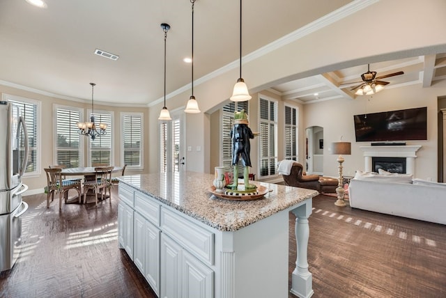 901 Jessica Ln, Prosper, TX 75078 - kitchen featuring stainless steel fridge, ceiling fan, arched walkways, a glass covered fireplace, and light stone countertops