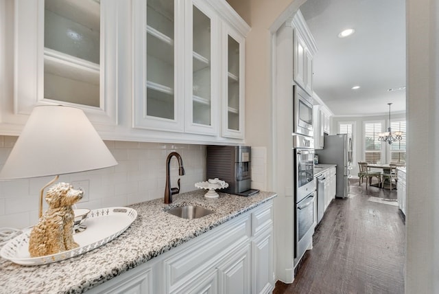 901 Jessica Ln, Prosper, TX 75078 - bar with a sink, appliances with stainless steel finishes, backsplash, dark wood-style flooring, and a chandelier
