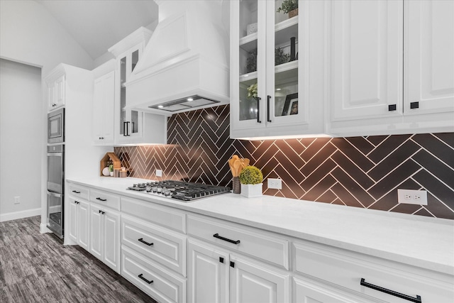 1015 Sable Dr, Rockwall, TX 75087 - kitchen with custom range hood, stainless steel appliances, tasteful backsplash, white cabinetry, and lofted ceiling