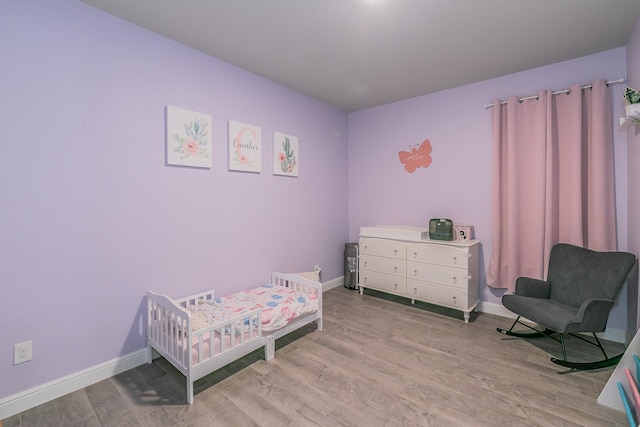 812 Holler Loop, Fort Worth, TX 76247 - bedroom with wood finished floors, baseboards, and a nursery area