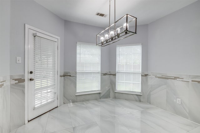 5283 W Cove Way, Grand Prairie, TX 75052 - unfurnished dining area with tile walls, a chandelier, and a wainscoted wall