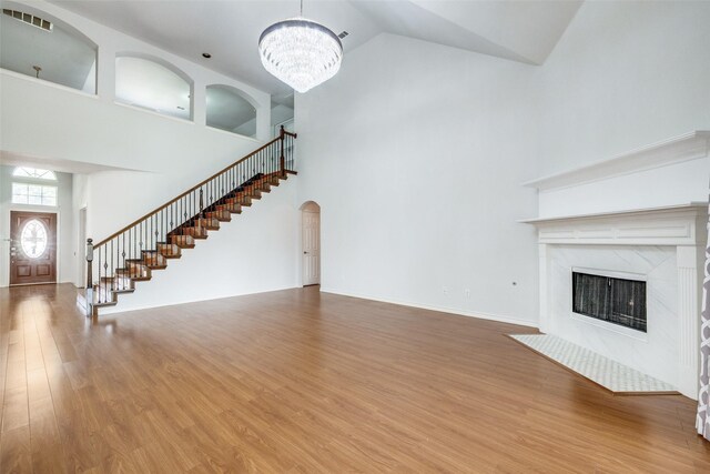 5283 W Cove Way, Grand Prairie, TX 75052 - unfurnished living room featuring high vaulted ceiling, stairs, a chandelier, wood finished floors, and a high end fireplace