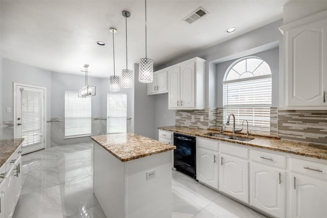 5283 W Cove Way, Grand Prairie, TX 75052 - kitchen featuring dishwasher, a sink, a center island, light stone countertops, and white cabinets