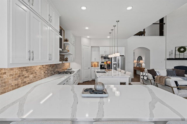 1720 Rolling Heights Ln, Fort Worth, TX 76008 - kitchen with stainless steel appliances, arched walkways, backsplash, white cabinets, and recessed lighting