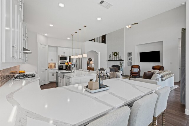 1720 Rolling Heights Ln, Fort Worth, TX 76008 - kitchen featuring appliances with stainless steel finishes, open floor plan, dark wood-style flooring, a sink, and a kitchen island with sink