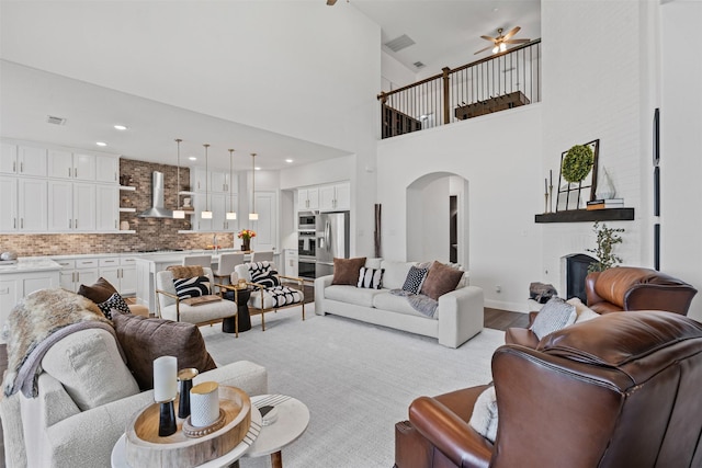 1720 Rolling Heights Ln, Fort Worth, TX 76008 - living area featuring arched walkways, a fireplace, light wood-type flooring, a ceiling fan, and baseboards